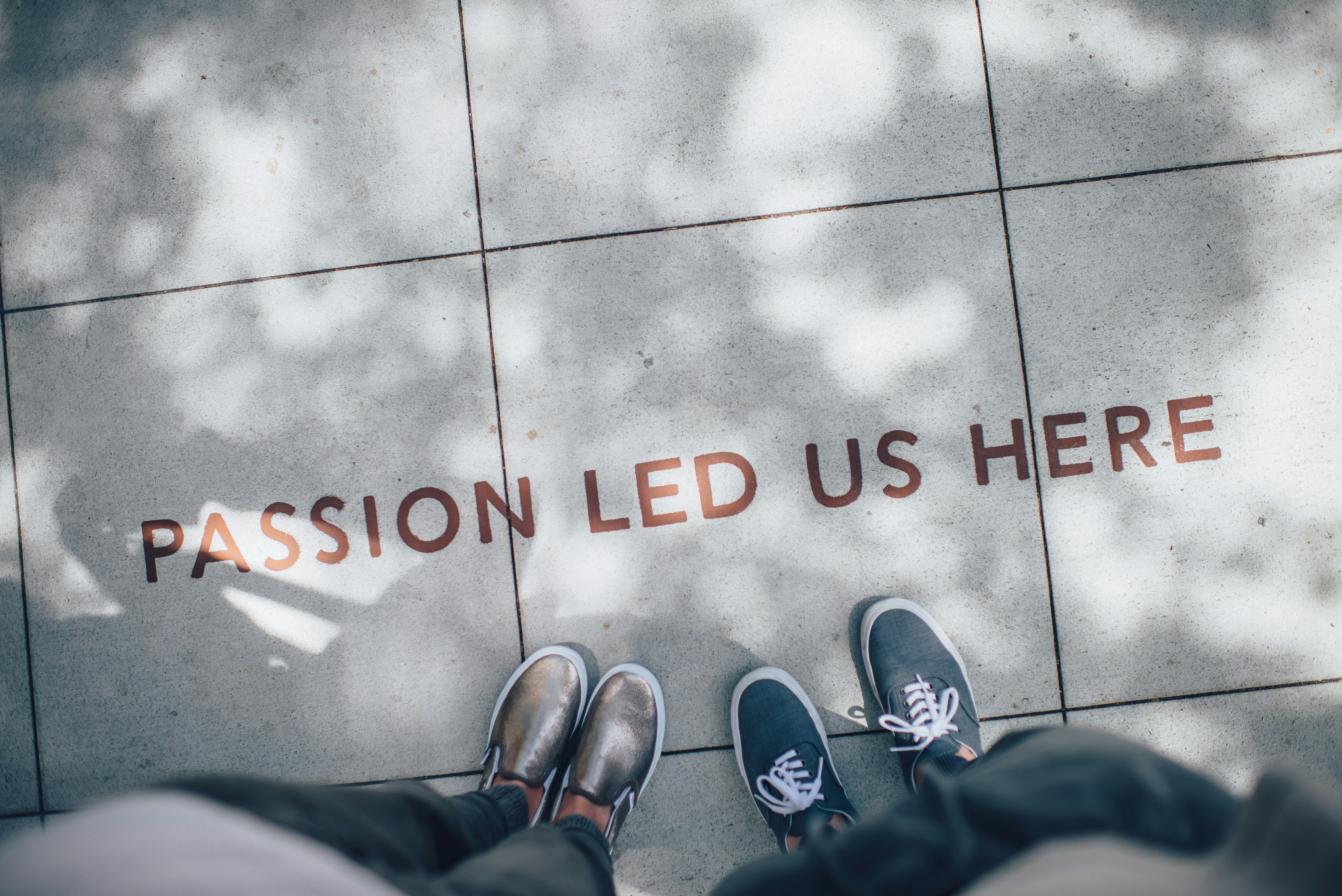 Passion led us here — two people standing on an inspirational sidewalk message